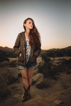 young woman standing on rocks outdoors 