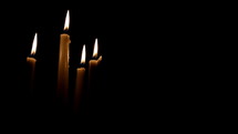 Flickering candles on a black background being blown out