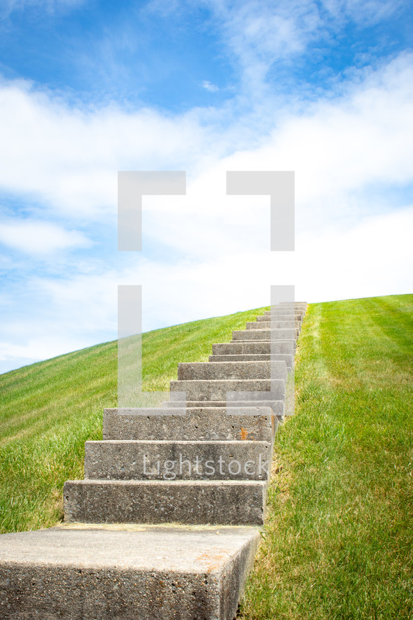 Concrete staircase going up over grassy hill horizontal