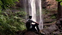 Young Man looking at waterfall.