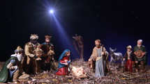 Nativity scene with figurines and star.
