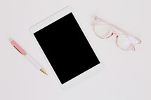 pen, tablet, and reading glasses 
