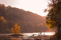 people exploring a riverbank in fall 