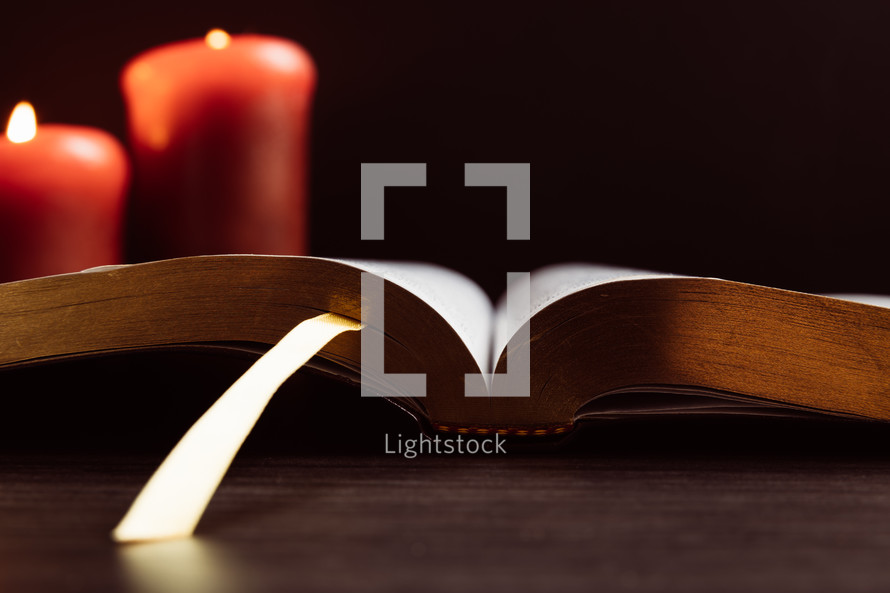 Red Christmas candles with open Bible