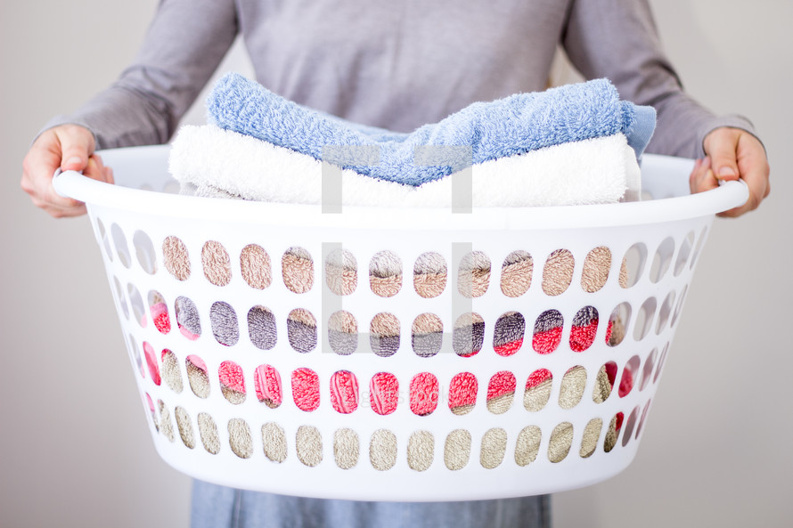 Lady holding washing basket with towels