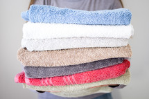 Lady holding stack of towels