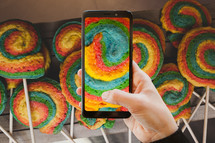 Using the camera with a mobile phone. Colorful pastry shaped like a pinwheel