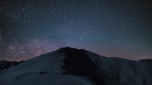 Time-laspe of Milky way galaxy stars over winter snowy mountains in cold starry night sky Astronomy
