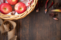 apples in a basket on a wood background 