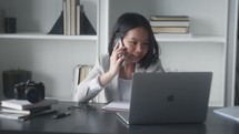 a young woman working in a home office on a phone call