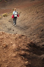 a woman hiking a path to a crater in Hawaii 