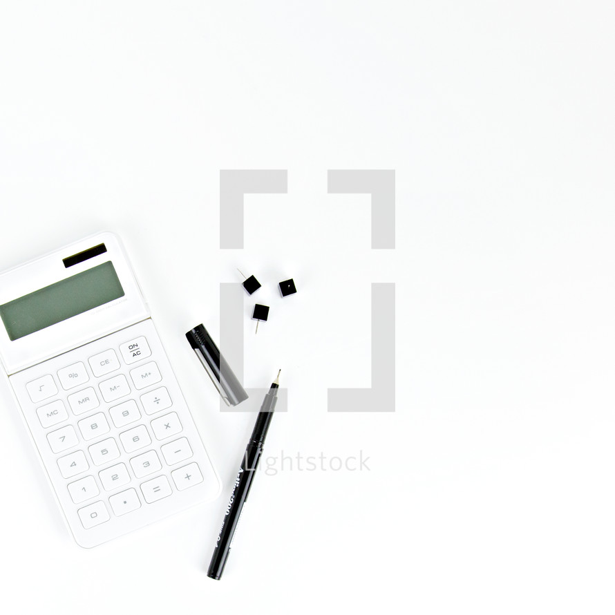 calculator, pen, and, tacks on a desk 