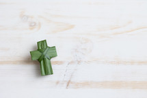 palm frond cross on white wood 