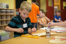 A little boy using watercolors in classroom
