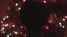 Boy looking at Christmas tree and lights.