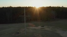 aerial view over a cross on a hill at sunset 