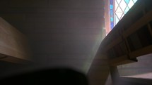 sunlight through a stained glass window shining on church pews 