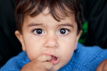 Young boy with fingers in mouth