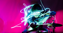 swirling lights around a drummer in a band on stage at a concert