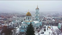 Aerial view of snow covered orthodox church in winter foggy town 4k