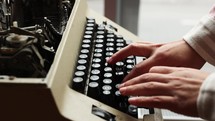 Slow motion side view of male hands type on keyboard of old manual typewriter.