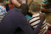 man with his arm around a child during a children's ministry