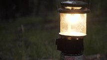 man turns on a propane lantern 