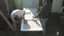 Men working to repair wooden door