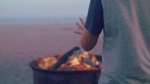 Person standing fire pit warming hands