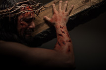 The suffering of Christ -- a beaten Jesus in His crown of thorns crying as he carries the cross.