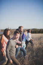 group of people walking outdoors through a field 