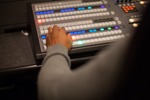 hands on a control panel for a sound system 