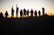 raised hands, praise, man, woman, silhouettes, group, people, row, standing, field, outdoors, worship 