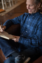 a man writing in a journal at a Bible study 