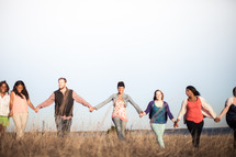 group holding hands in fellowship outdoors 