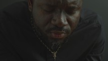 Black Catholic Priest Holding Holy Bible and Saying a Prayer