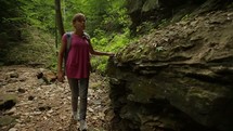 a woman with a walking stick hiking on a trail 