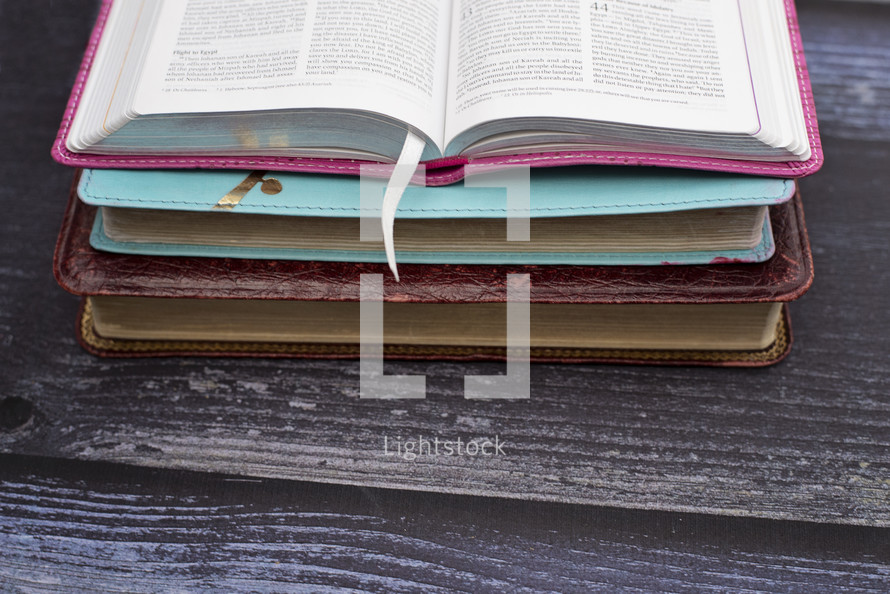 stacked Bibles on wood background 