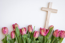 Wood cross with border of pink tulips on a white background