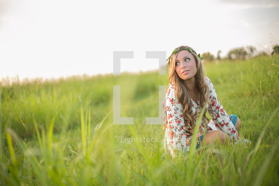 young woman sitting in tall grass 
