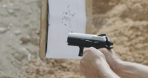 Close up footage of a hand gun firing in a firing range with cartridge flying away