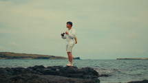 Asian man taking pictures around the sea
