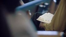 person reading their Bible during a worship service 