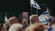 Signs held up of a kidnapped man in Israel in a crowd of Israel supporters