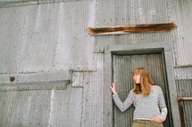 a woman standing in front of a sheet metal building 