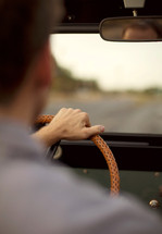 Man with hand hand on steering wheel