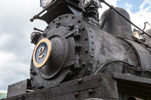 Close up of large black iron locomotive train engine front 
