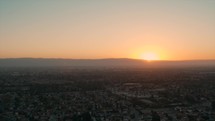 aerial view over suburbs of a city at sunset 
