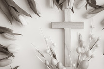 Cross and tulips with easter eggs on white background in sepia