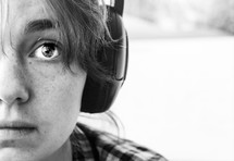 a child with freckles listening to headphones